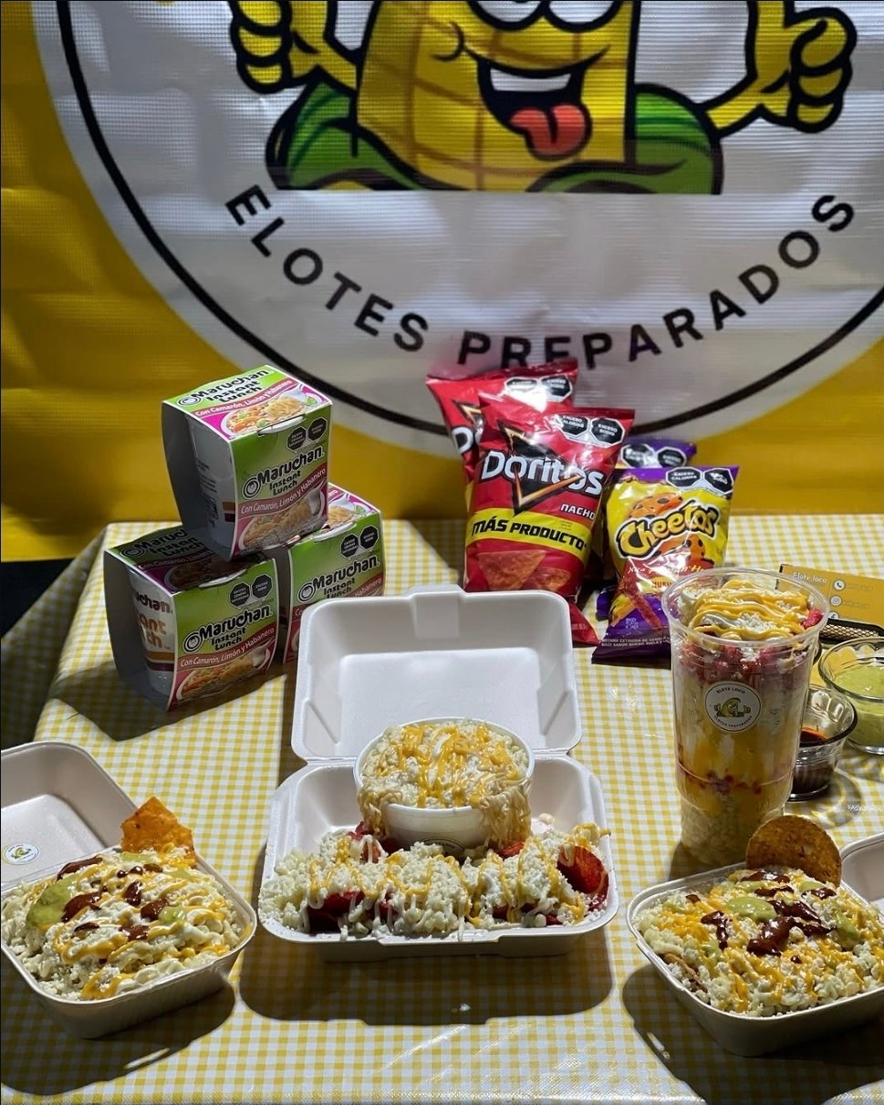 Charolas de tostielotes, Marucha elote y un Vaso Loco sobre la mesa de Elote Loco